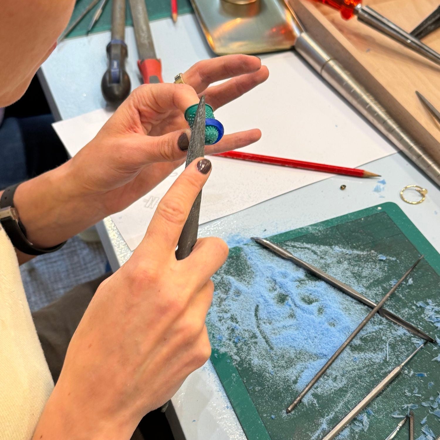 Hände feilen im Molokai Wax Carving Workshop in Zürich an einem Ringmodell aus Wachs
