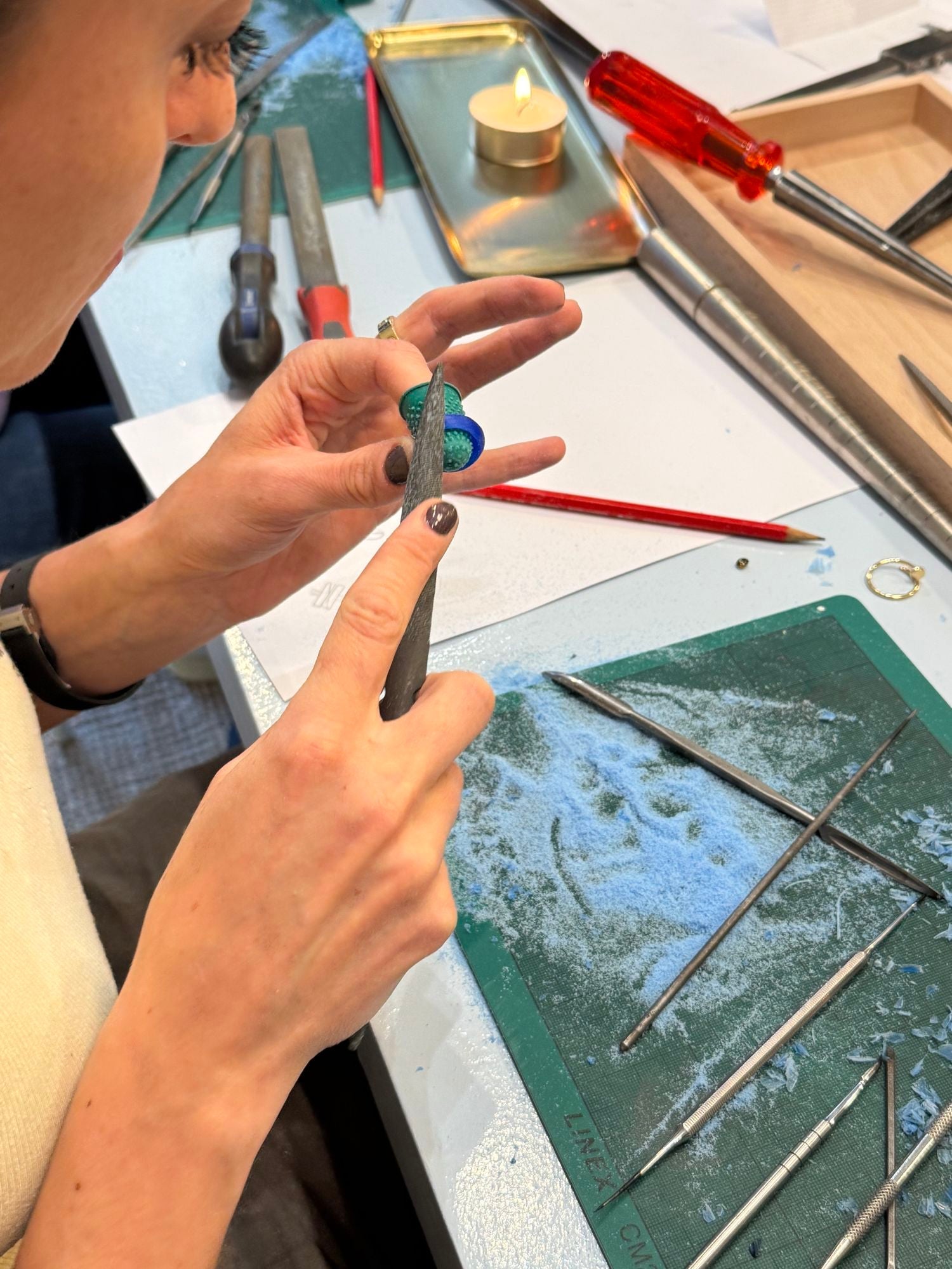 Hände feilen im Molokai Wax Carving Workshop in Zürich an einem Ringmodell aus Wachs