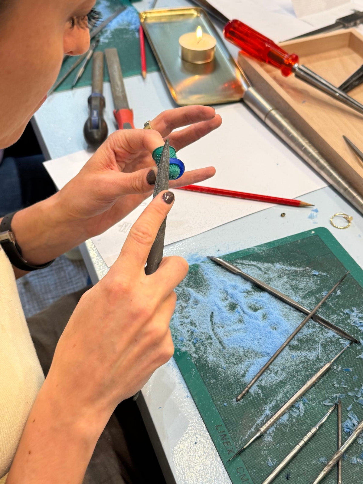 Hände feilen im Molokai Wax Carving Workshop in Zürich an einem Ringmodell aus Wachs